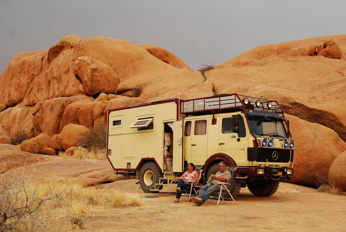 Overland campervan travelling through desert landscape